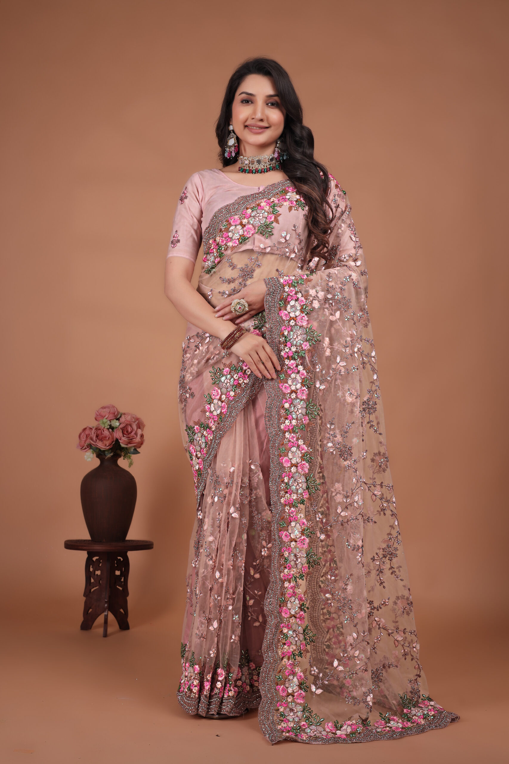 peach net saree with Swarovski work and a detailed floral embroidered border by Ritual Styles.